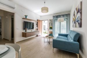 un soggiorno con un divano blu e un tavolo di Mary House by BarbarHouse a Taranto