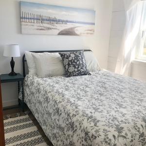 a bedroom with a bed with a comforter and pillows at Magnolia House PEI in Souris