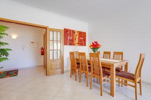 Un comedor con mesa y sillas de madera. en Apartamento Casa Matilda, en Armação de Pêra