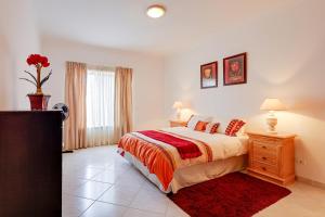 a bedroom with a bed and a red rug at Apartamento Casa Matilda in Armação de Pêra
