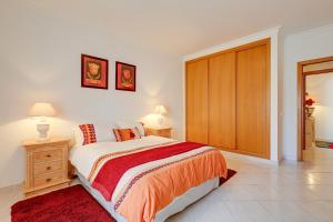 a bedroom with a bed and a wooden closet at Apartamento Casa Matilda in Armação de Pêra