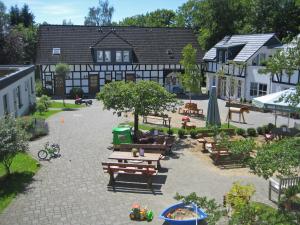a courtyard with wooden benches and a building at Birkenhof - Ferienhof, Landcafe und Rösterei in Schmallenberg