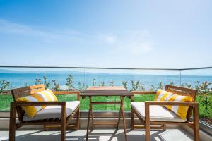 a patio with a table and chairs and the ocean at Azzurro e Verde by RentalsPro - Nea Potidaia Halkidiki in Nea Potidaea +58 photos