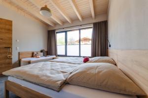a bedroom with a large bed with a large window at Birkenhof - Ferienhof, Landcafe und Rösterei in Schmallenberg