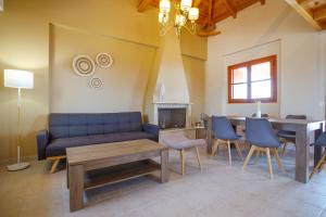 a living room with a blue couch and a table at La Pietra Maisonettes in Neokhórion +47 photos