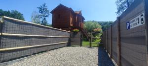 a gate to a fence in front of a house at Cabane romantique avec spa privatif insolite en Alsace in Aspach
