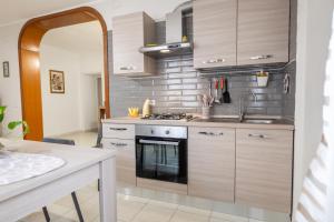 una cucina con mobili in legno e un forno a piano cottura di Casa Josy a Francavilla di Sicilia