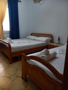 a room with three beds and a window at GuestHouseMantho in Gjirokastër