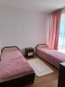 een slaapkamer met twee bedden en een raam bij Apartament Savva in Byala