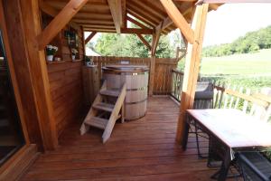 a screened porch with a barrel and a table and benches at Cabane romantique avec spa privatif insolite en Alsace in Aspach +33 photos