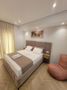 a bedroom with a large bed and a chair at luxury studio's J&M in Sarandë +43 photos