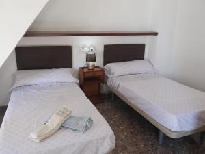 two beds with a pair of shoes on top of them at Casa Vistalmar in Cullera