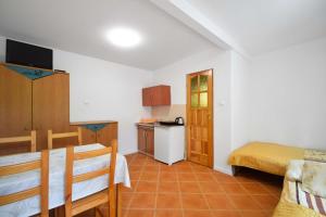 a room with a kitchen and a dining room with a table at Domek Campingowy Żółty in Pogorzelica