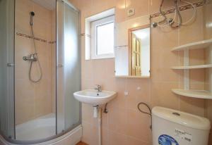 a bathroom with a shower and a sink and a mirror at Domek Campingowy Żółty in Pogorzelica