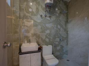 un baño con inodoro y lavabo en Perfectstayz Value Alpine Retreat, en Rishīkesh