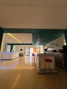 a kitchen with a counter and stools in a room at Hostal San Carlos in Lloret de Mar