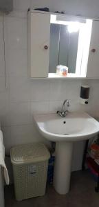 Un baño con un lavabo blanco y un espejo. en Ozias House, en Oziás
