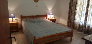 Un dormitorio con una cama y dos mesitas de noche con lámparas. en Ozias House, en Oziás