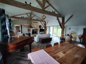 a living room with a wooden table and a couch at Grande maison au calme in Saint-André-de-Cubzac