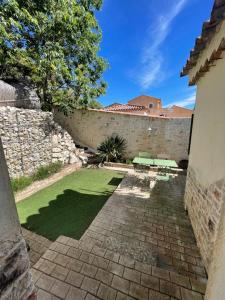een binnenplaats met een stenen muur en groen gras bij Maisonnette avec terrasse et patio à Cassis in Cassis