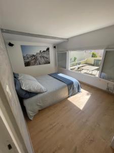 een slaapkamer met een bed en een groot raam bij Maisonnette avec terrasse et patio à Cassis in Cassis