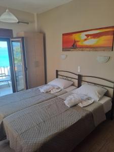 a bedroom with two beds with towels on them at DIOLKOS APARTEMENT in Nea Roda