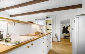 Una cocina con gabinetes blancos y un refrigerador blanco. en 2 Bedroom Lovely Home In Thisted, en Thisted 9 fotos más