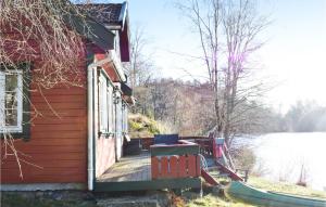 a house with a wooden deck with a slide at Pet Friendly Home In Lyngdal in Lyngdal +7 photos