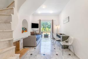 ein Wohnzimmer mit einer Couch und einem Tisch und Stühlen in der Unterkunft Doliva Studio Chris private pool in Agios Gordios