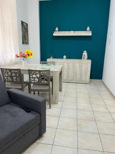 salon ze stołem i niebieską ścianą w obiekcie Joya apartament w mieście Tarent +10 zdjęć