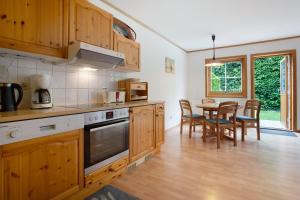 a kitchen with wooden cabinets and a table with chairs at Haus Albatros Wohnung 2 in Ostseebad Koserow +24 photos