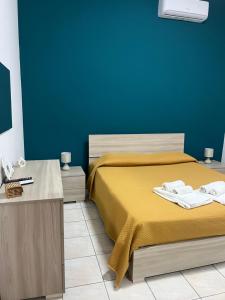 sypialnia z łóżkiem i niebieską ścianą w obiekcie Joya apartament w mieście Tarent
