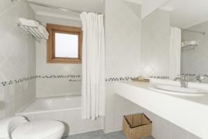 y baño con bañera, aseo y lavamanos. en Hotel Las Torres Patagonia, en Torres del Paine