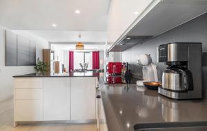 a kitchen with white cabinets and a counter top at Nice Apartment In Estepona With Wifi in Estepona +19 photos