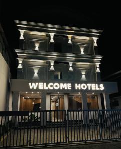 德里久尔Welcome Hotels的建筑物正面的欢迎酒店标志