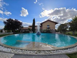 a large pool with a fountain in front of a house at Finca La Calancha in Cuerva
