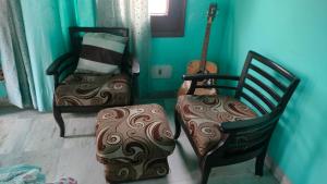 two chairs and a guitar in a room at Sweet Home 8 Chandigarh in Chandīgarh +4 photos