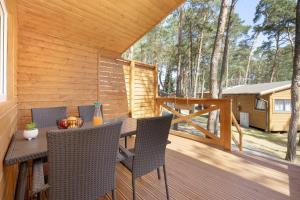 a patio with a table and chairs on a deck at Domki letniskowe Arkadia in Pobierowo