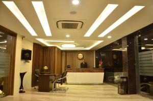 a man sitting at a reception desk in a lobby at The Ved Mantra in Gwalior