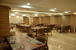 a restaurant with tables and chairs in a room at The Ved Mantra in Gwalior