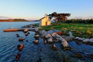 a small church in the middle of a body of water at Sea and Sun Pakoštane in Pakoštane