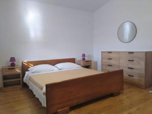 a bedroom with a bed and a dresser and a mirror at Sea and Sun Pakoštane in Pakoštane