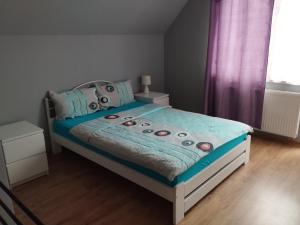 sypialnia z łóżkiem z niebieską kołdrą w obiekcie ABM Noclegi w mieście Mikołajki