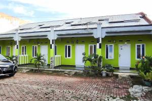 a green house with a car parked in front of it at Ayi The Costel Syariah Bengkulu Mitra RedDoorz in Curup +17 photos