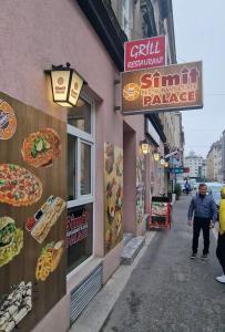 a man walking down a street in front of a pizzeria at Palace Apartment in Vienna