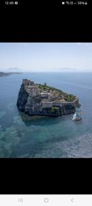 a small island with a boat in the water at Appartamento L'Orchidea in Forio d'Ischia