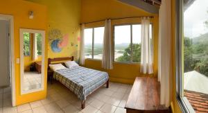 a bedroom with a bed and a large window at Banana Leaf Eco Hostel in Barra de Guaratiba +37 photos