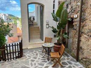 a patio with a table and chairs and a plant at Villa Il Guardingo in Rio nellʼElba