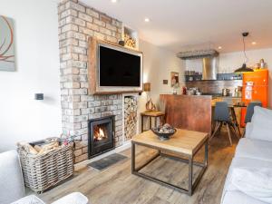 un soggiorno con camino e TV di Wee Cottage a Moffat