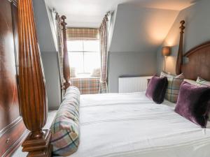 una camera da letto con un letto grande in una stanza di Wee Cottage a Moffat